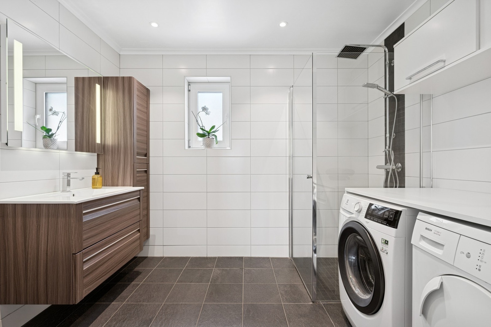 Badet fremstår som moderne og gjennomført med flislagte veggflater og flislagt gulv. Galleribilde