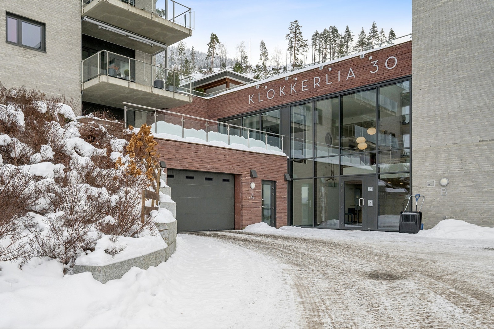Det er et flott inngangsparti til blokka, og innkjøringen til garasjen er like ved. Her er det både vaskehall og skibod. Galleribilde