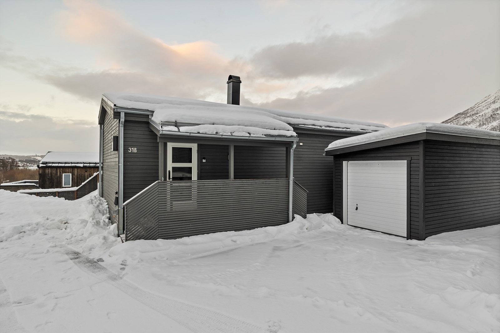 Boligen har takoverbygd inngangsparti og garasje Galleribilde