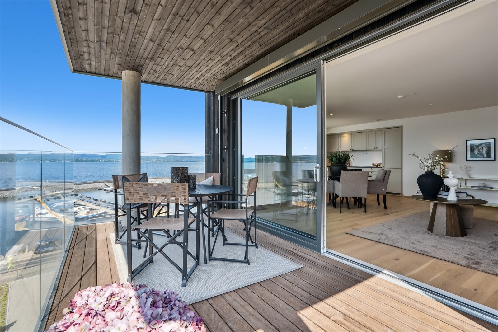 Leilighetens lune, overbygde balkong er mer enn stor nok til både spiseplass og salong. Galleribilde