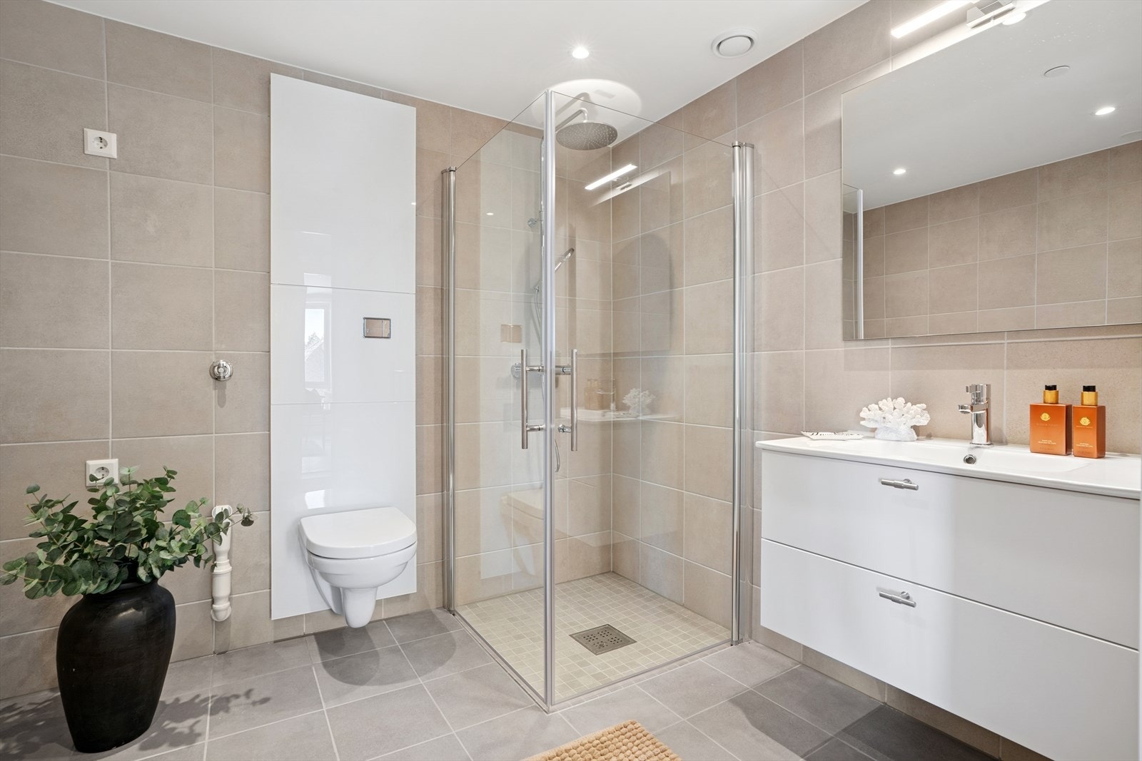 Hovedbaderommet er romslig, og er innredet med en pen baderomsinnredning med heldekkende servant, speil, vegghengt toalett, dusjhjørne med glassdører. Videre er det opplegg for vaskemaskin her og flexit balansert ventilasjon med avtrekk på bad. Galleribilde