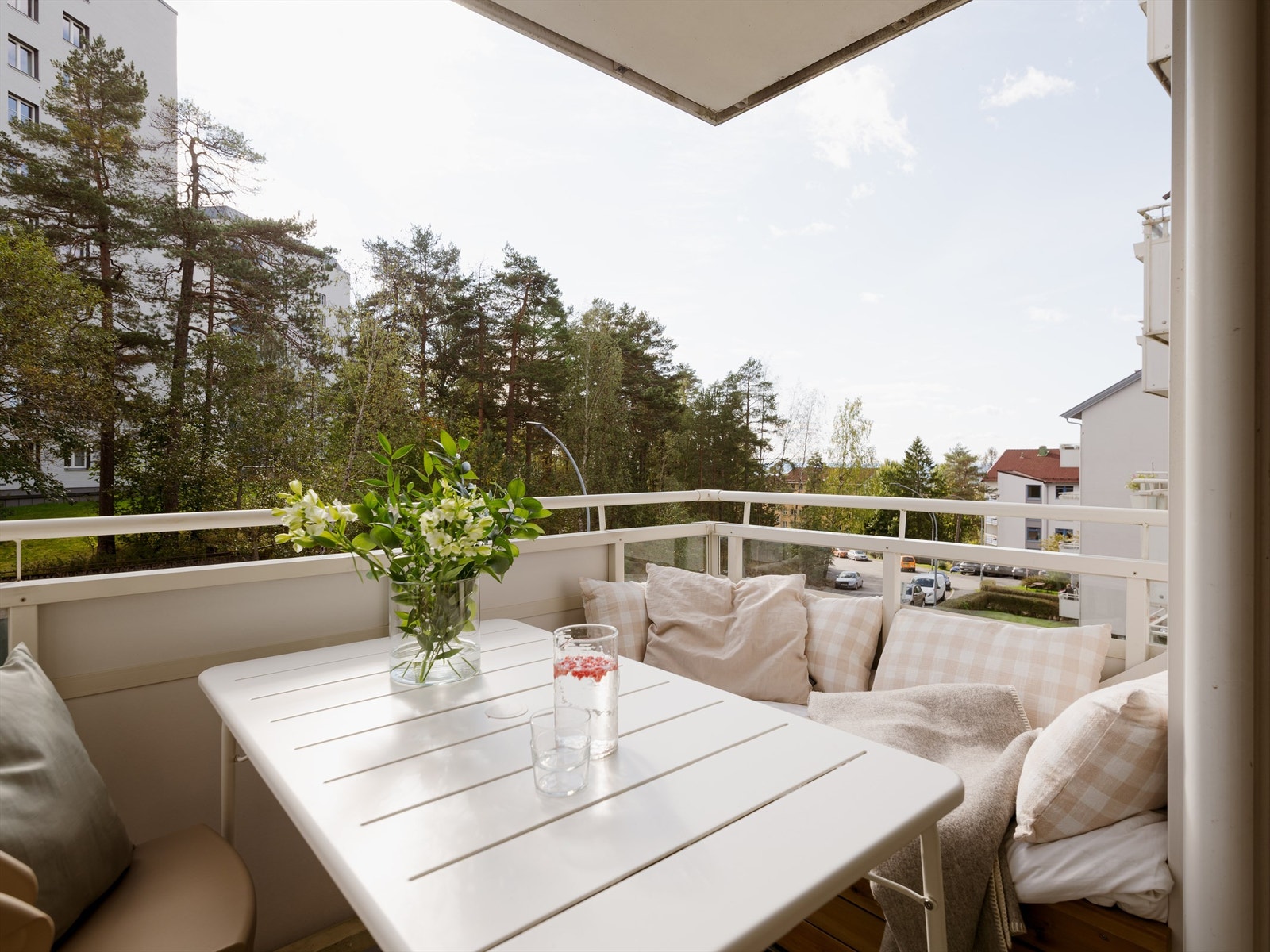 Den sydvendte balkongen på 7m² har blant annet en plassbygget sofa som utnytter plassen optimalt og herlig utsyn over tretoppene Galleribilde