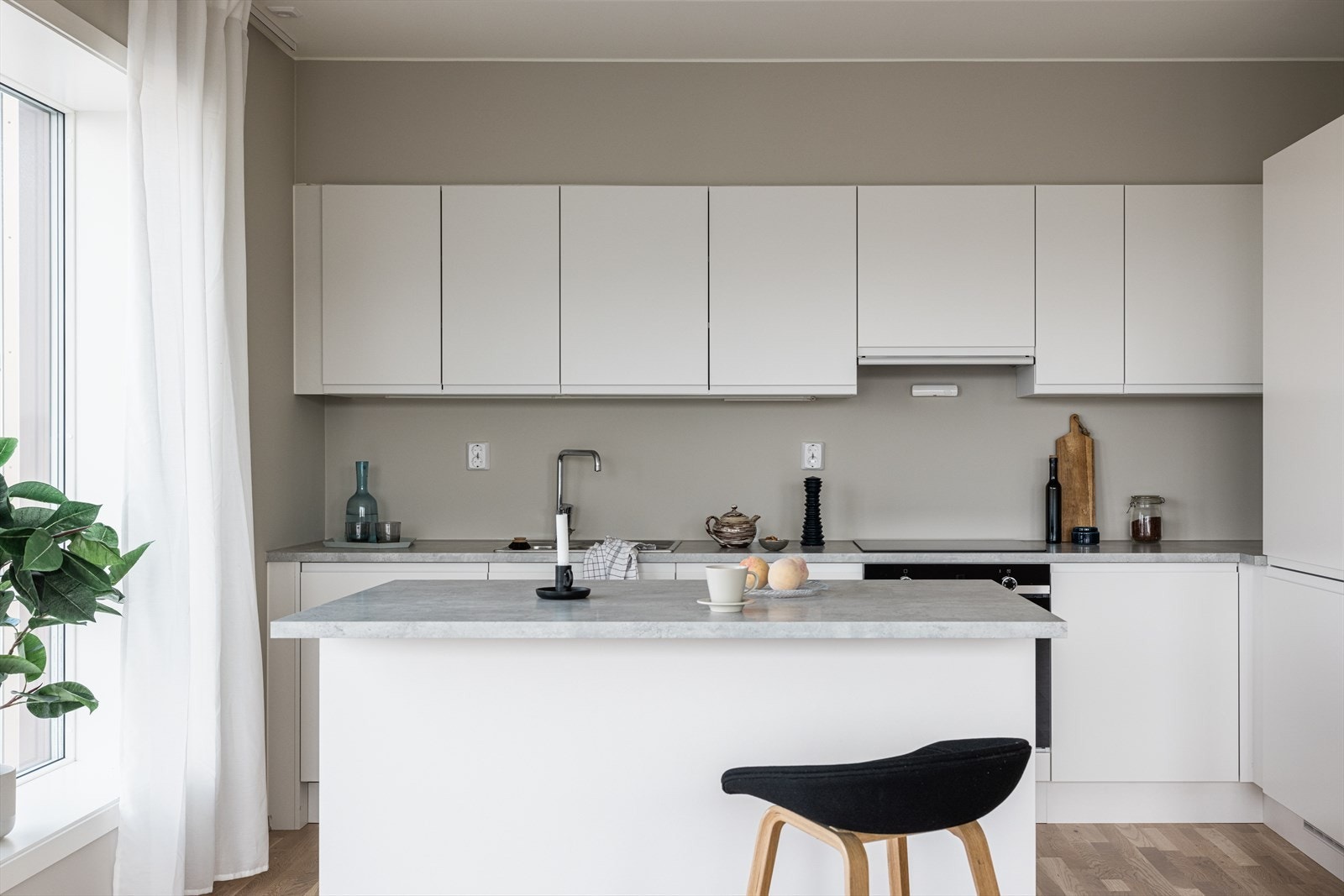 Det er montert en heldekkende laminat benkeplate i fargen lys betong, samt tilkoblet kjøkkenvask i stål. Galleribilde