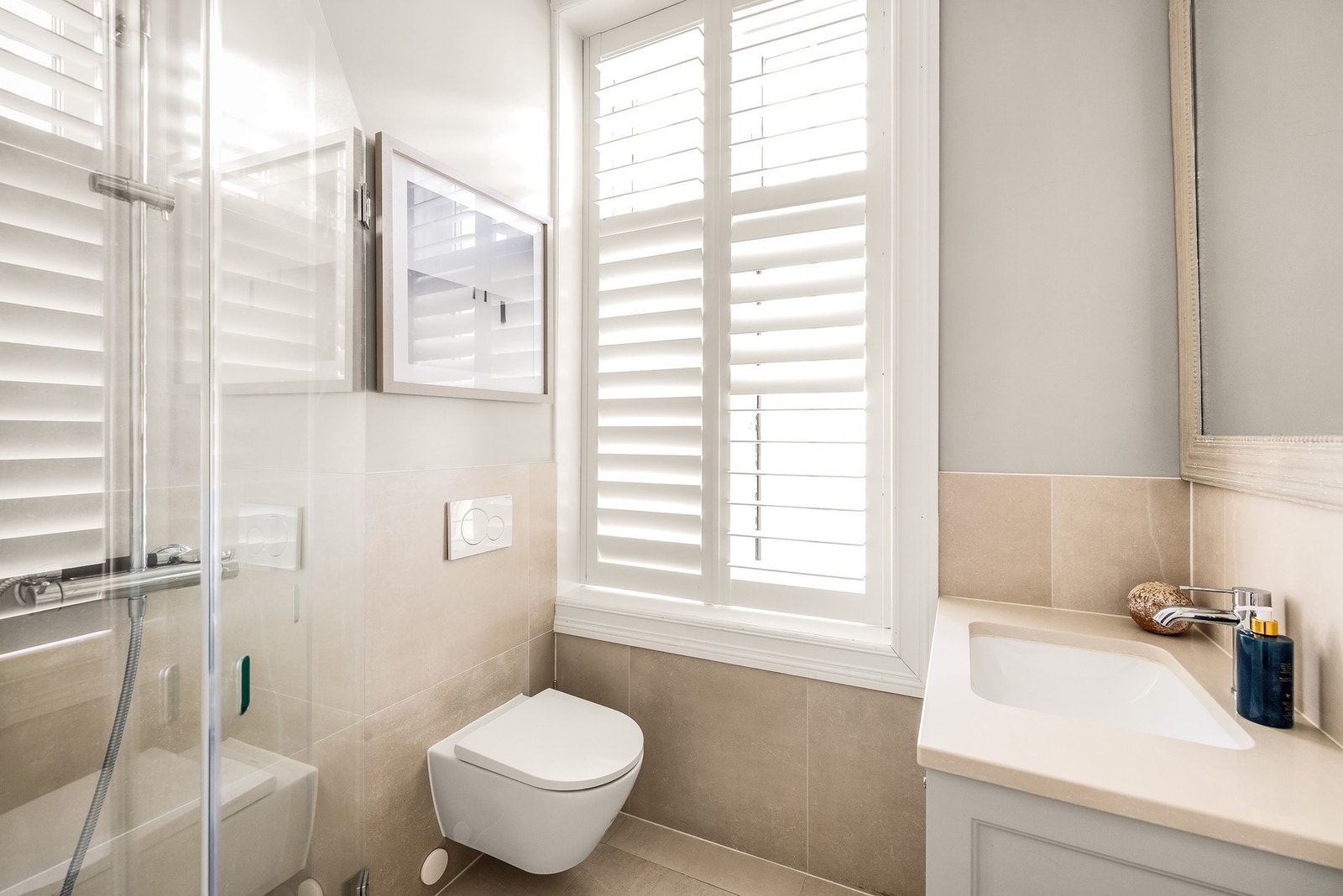 Leilighetens andre bad ble også renovert i 2024, og har dusjhjørne, servant med underskap og vegghengt toalett. Vindu med justerbare shutters gir godt lysinnslipp og mulighet for skjerming etter behov Galleribilde