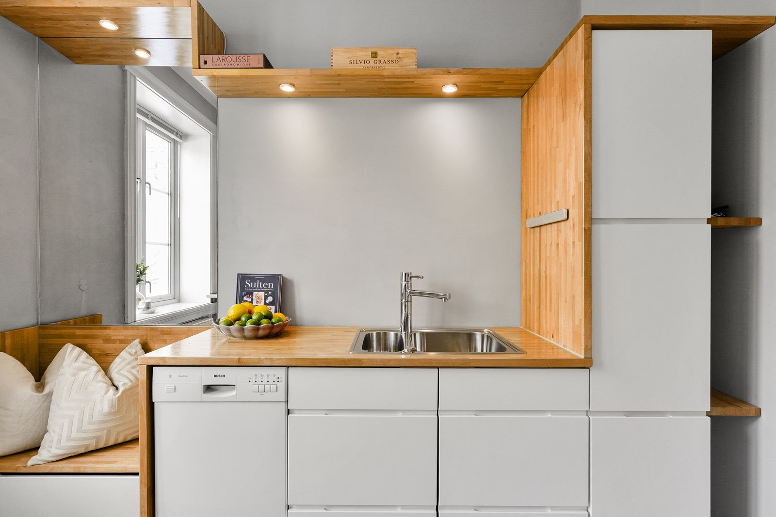 Den innebygde sittebenken ved vinduet skaper en hyggelig spiseplass og bidrar til en sosial og innbydende atmosfære. Galleribilde