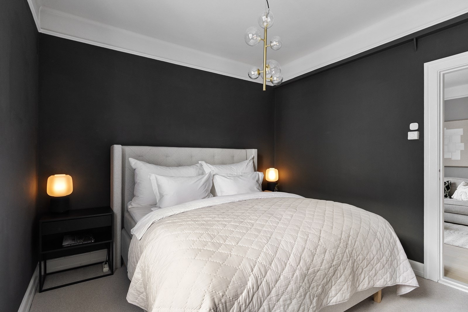 Samspillet mellom mørke og lyse toner gir et harmonisk helhetsinntrykk og gjør rommet godt egnet for hvile og avslapning, samtidig som vinduet slipper inn behagelig dagslys. Galleribilde