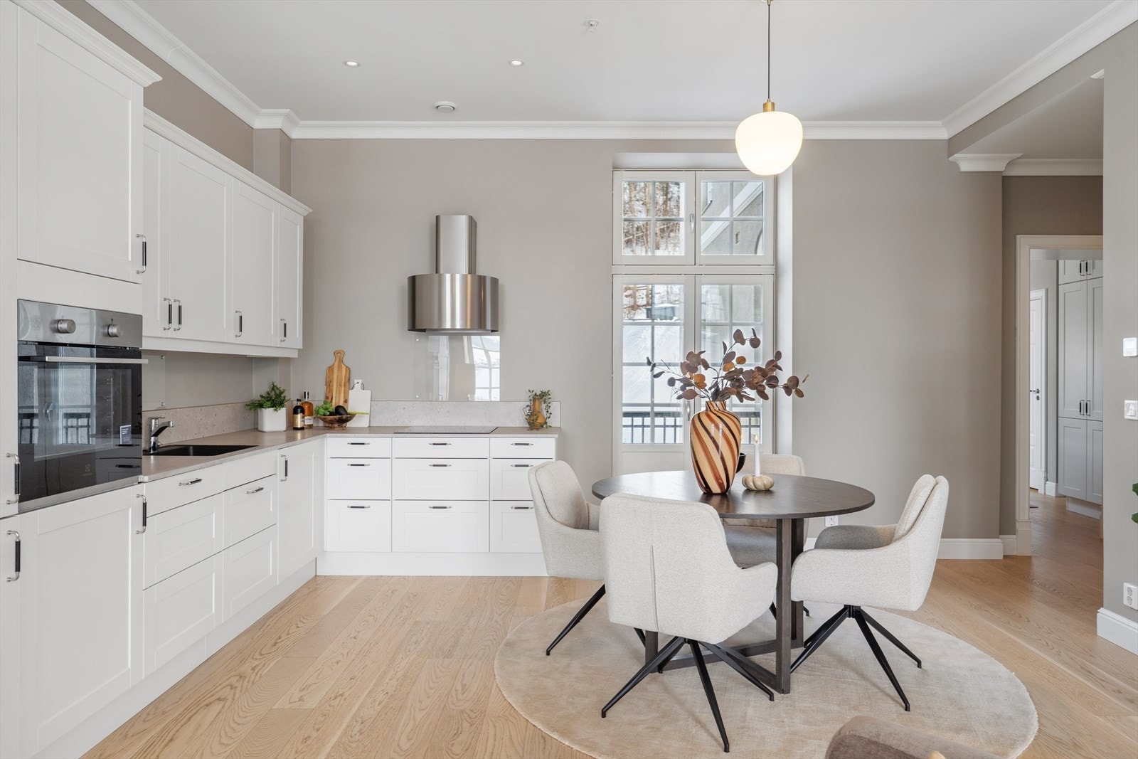 Lyst og tidløst kjøkken med profilerte fronter og benkeplate i komposittstein. Galleribilde