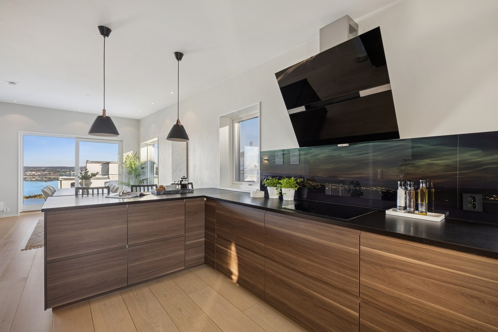 Kjøkken med barløsning mot spisestue med frokostplass. Galleribilde