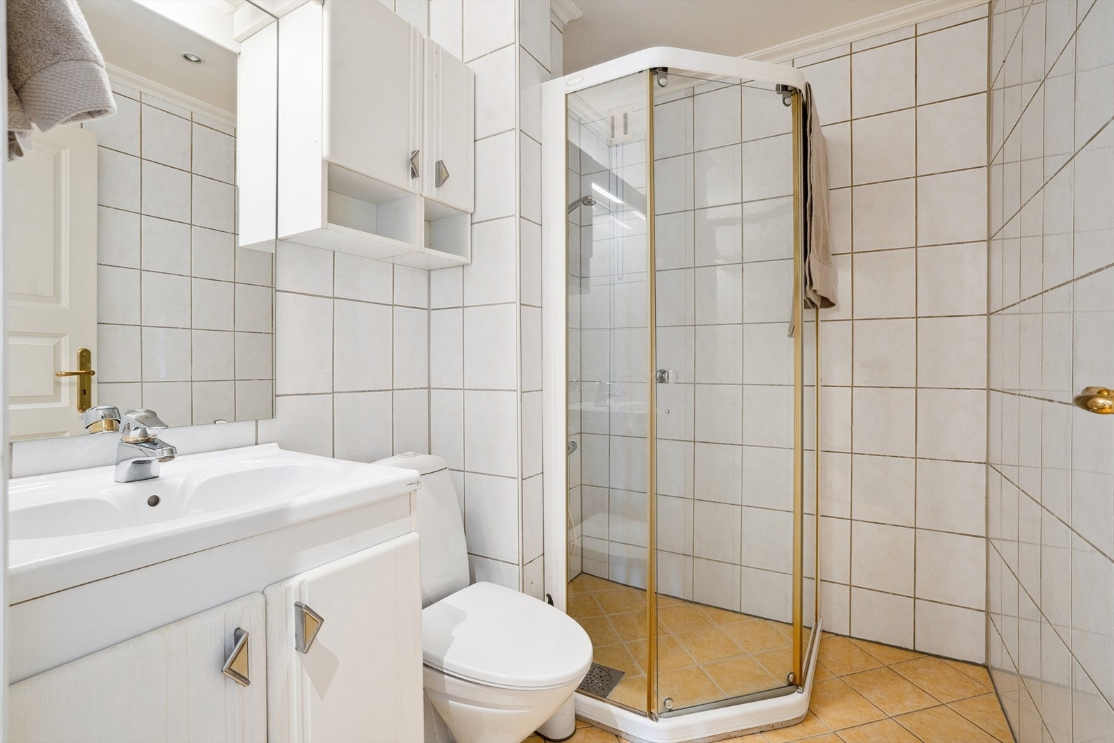 Badet er helfliset og utstyrt med dusjhjørne, WC og servant med underskap. Galleribilde