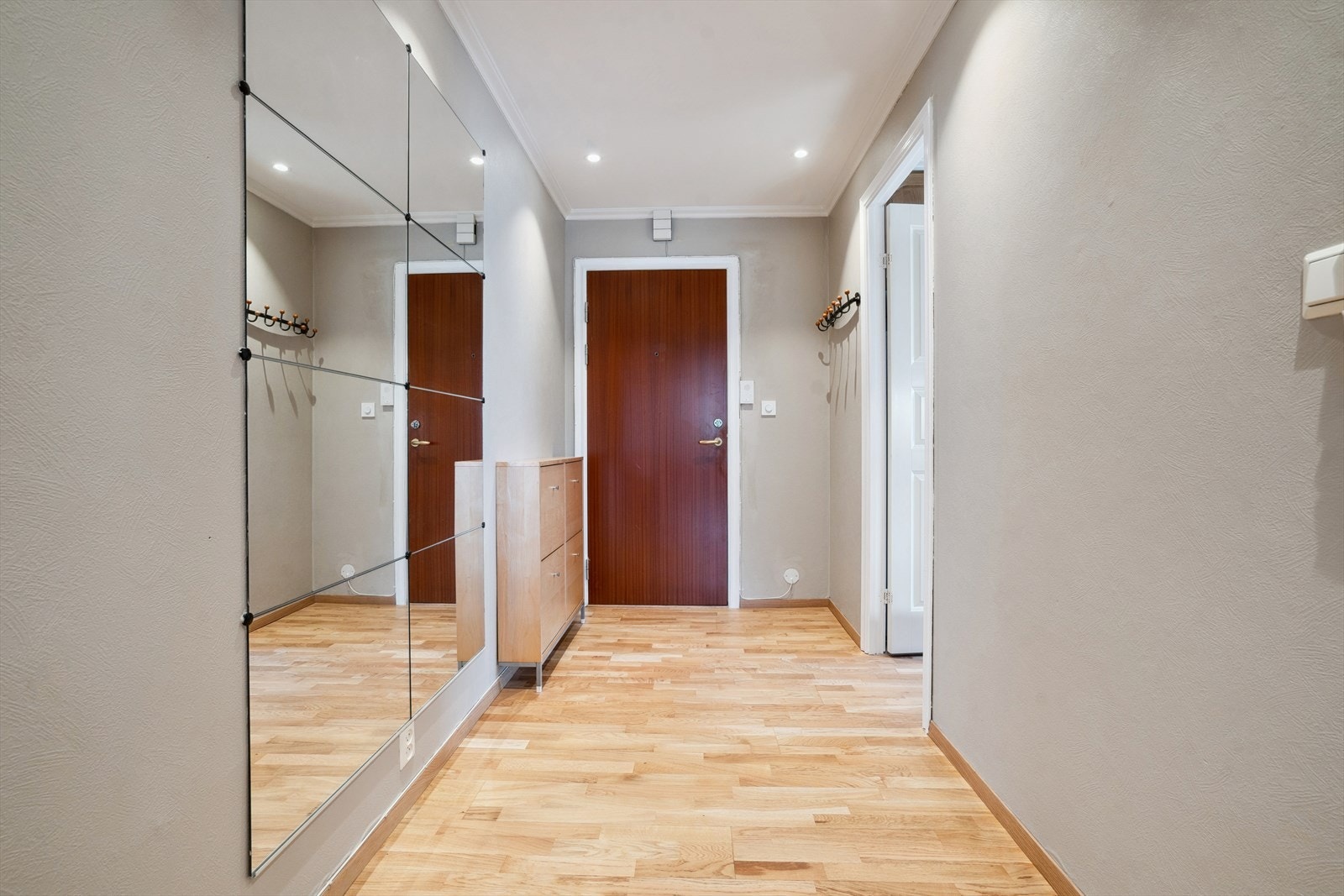 Velkommen inn i en romslig gang med parkett på gulvet og downlights i himling. Rikelig plass til garderobeløsninger. Galleribilde