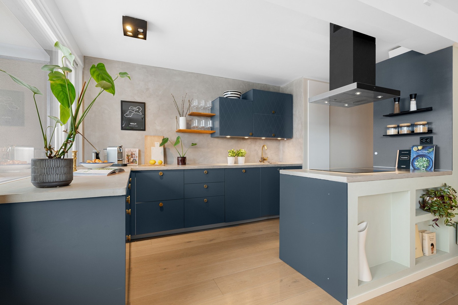 Innredningen har fronter fra Superfront i en dyp blåtone, kombinert med plasstøpt benkeplate i betong som gir et helhetlig og solid uttrykk. Galleribilde