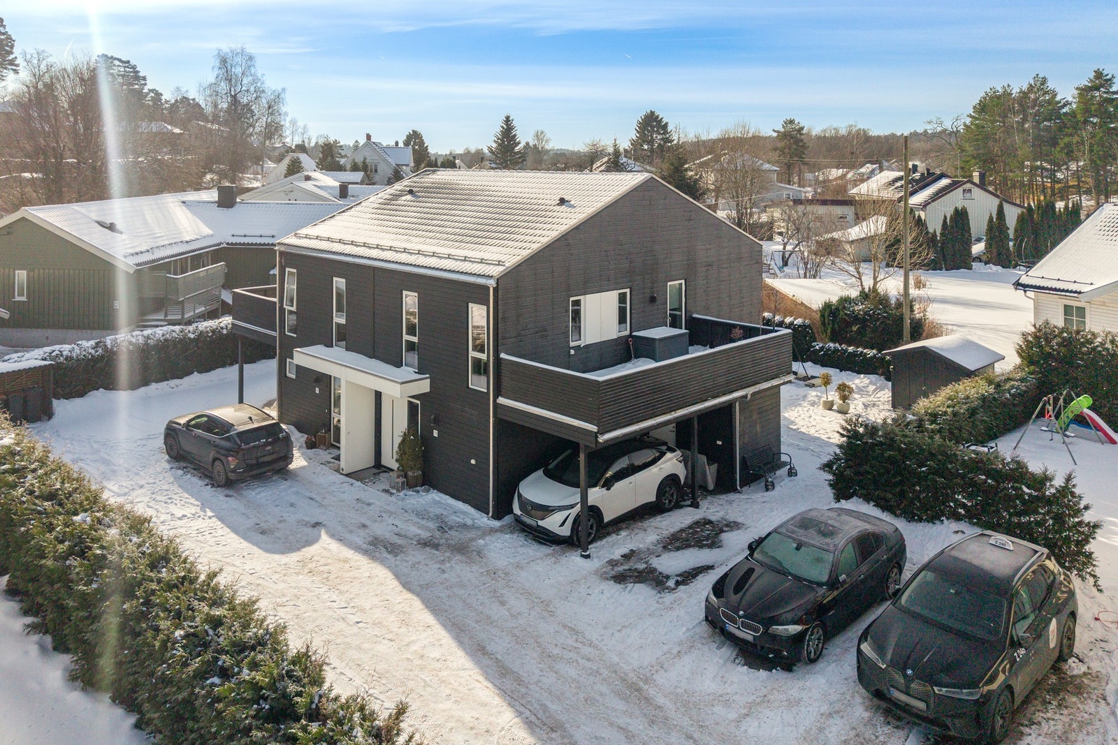 Stilren og moderne fasade med carport omed elbil lader Galleribilde