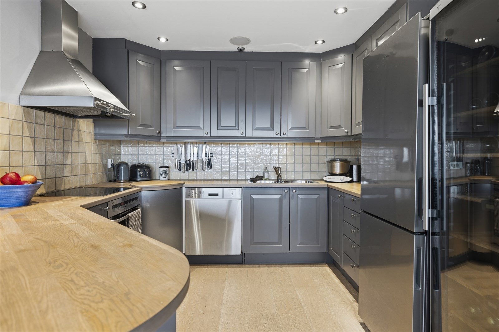 Pen og praktisk kjøkkeninnrening med heltre benkeplate. Integrert koketopp, stekeovn og oppvaskmaskin. Frittstående kjøl/frys. Praktisk kjøkkenøy med sitteplasser Galleribilde