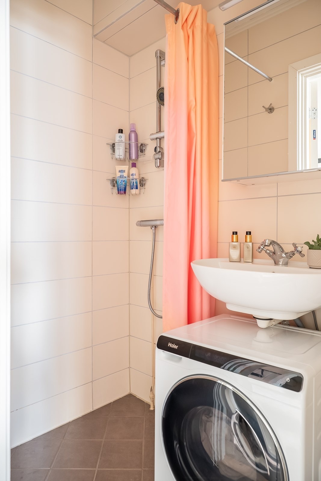 Flislagt bad med dusj og opplegg for vaskemaskin. Galleribilde