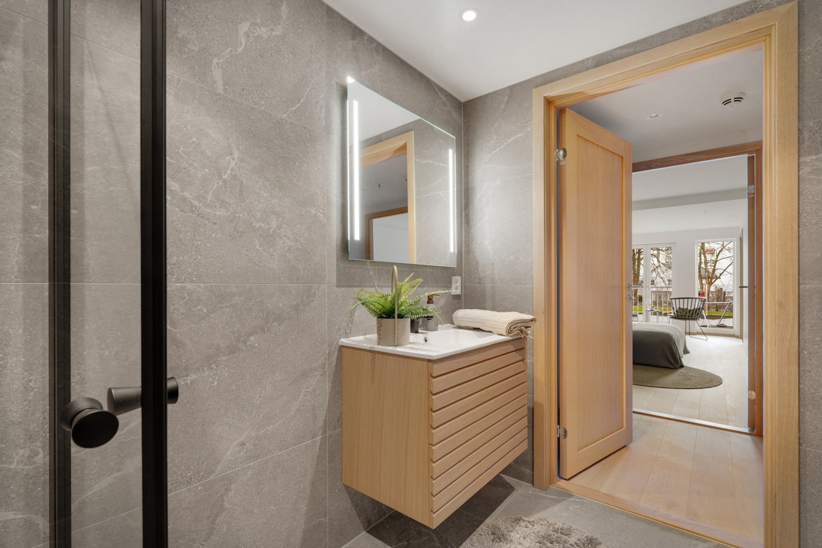 Badet er innredet med 80 cm servantmøbel av type MIE med Ada 50 Slim servant i porselen fra Viking bad. Videre er badet innredet med speil med lys, dusj med glassdører og vegghengt toalett. NB - Bildene er fra naboleiligheten. Galleribilde