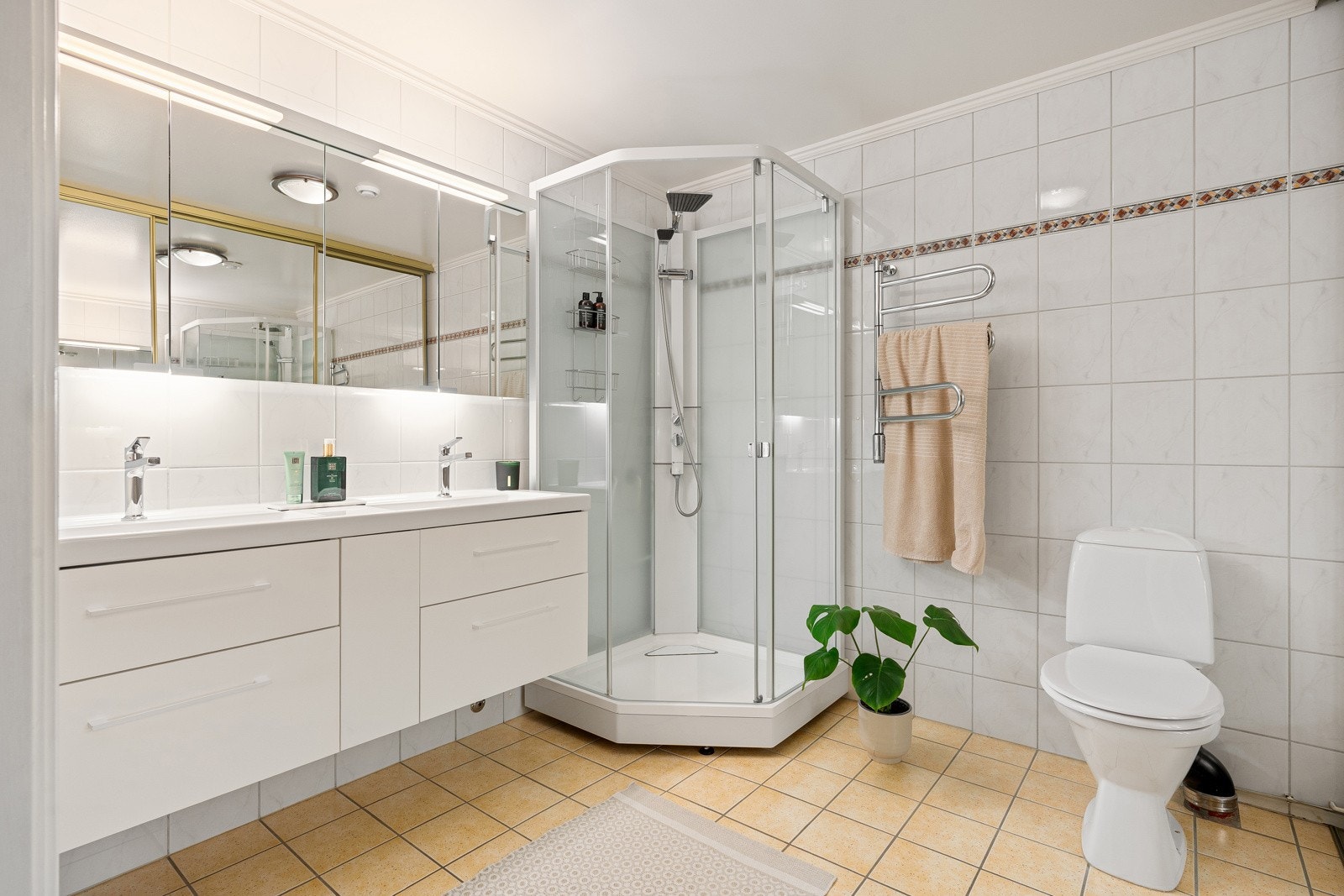 Stort bad med dusjkabinett, wc og baderomsinnredning med dobbel servant og god oppbevaringsplass.