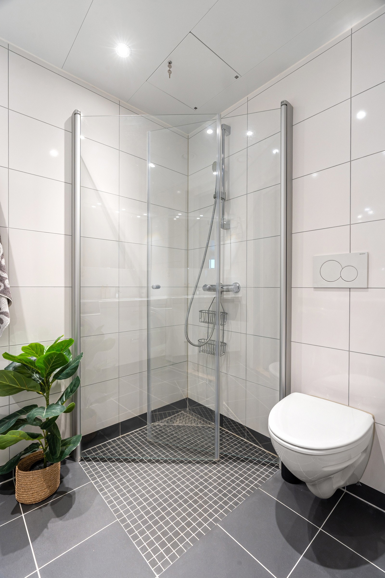 Badet har praktiske løsninger som dusjhjørne med innfellbare dører og vegghengt toalett.