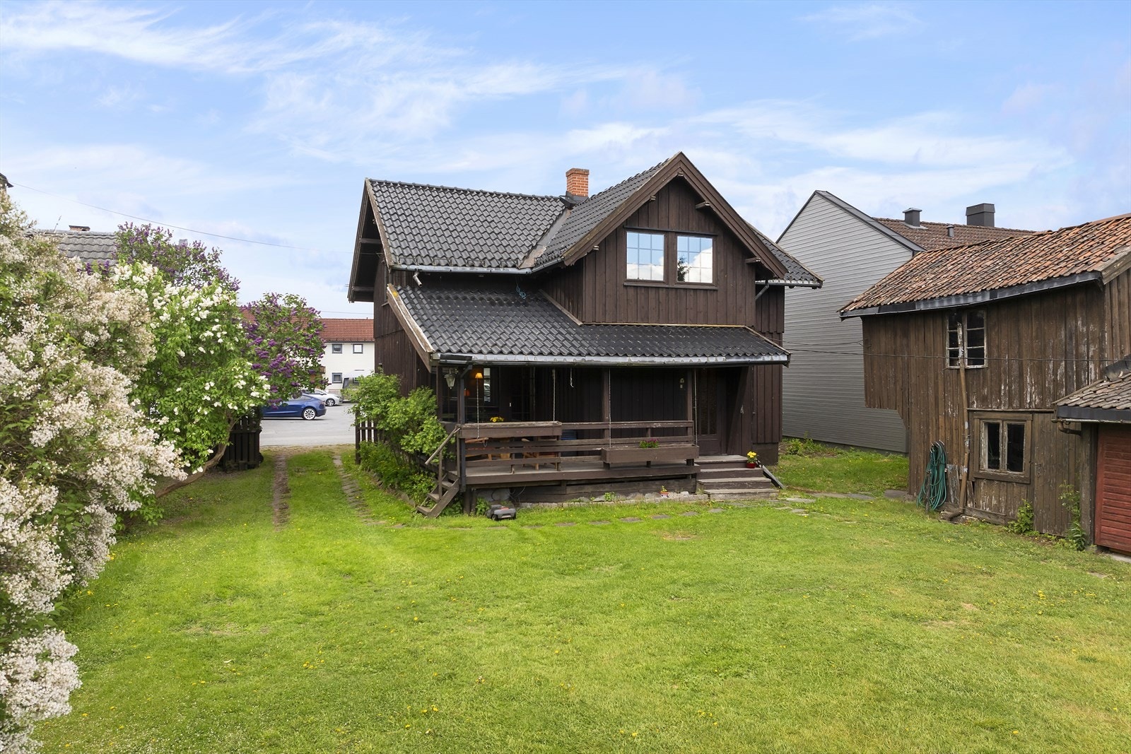 Eiendommen har en relativt flat tomt, opparbeidet med plen, prydbusker og hekk. Galleribilde