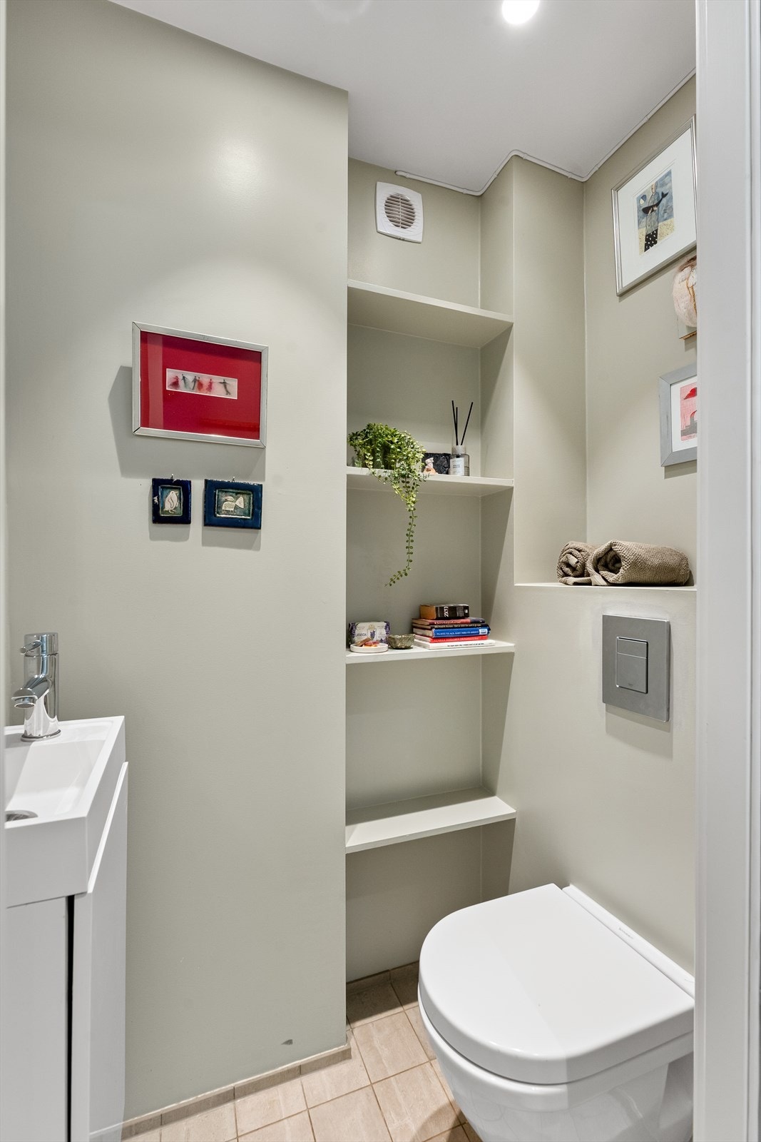 Praktisk gjestetoalett i første etasje med integrerte hyller for oppbevaring. Galleribilde