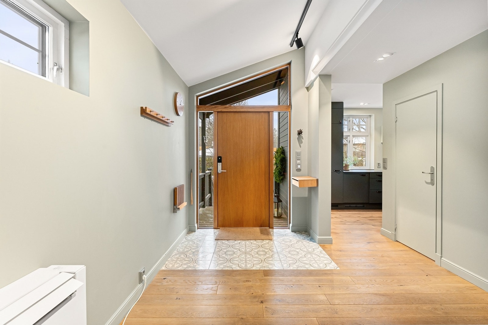 Velkommen inn i en lys og romslig entré med heltre eikedør og dekorative gulvfliser. Galleribilde