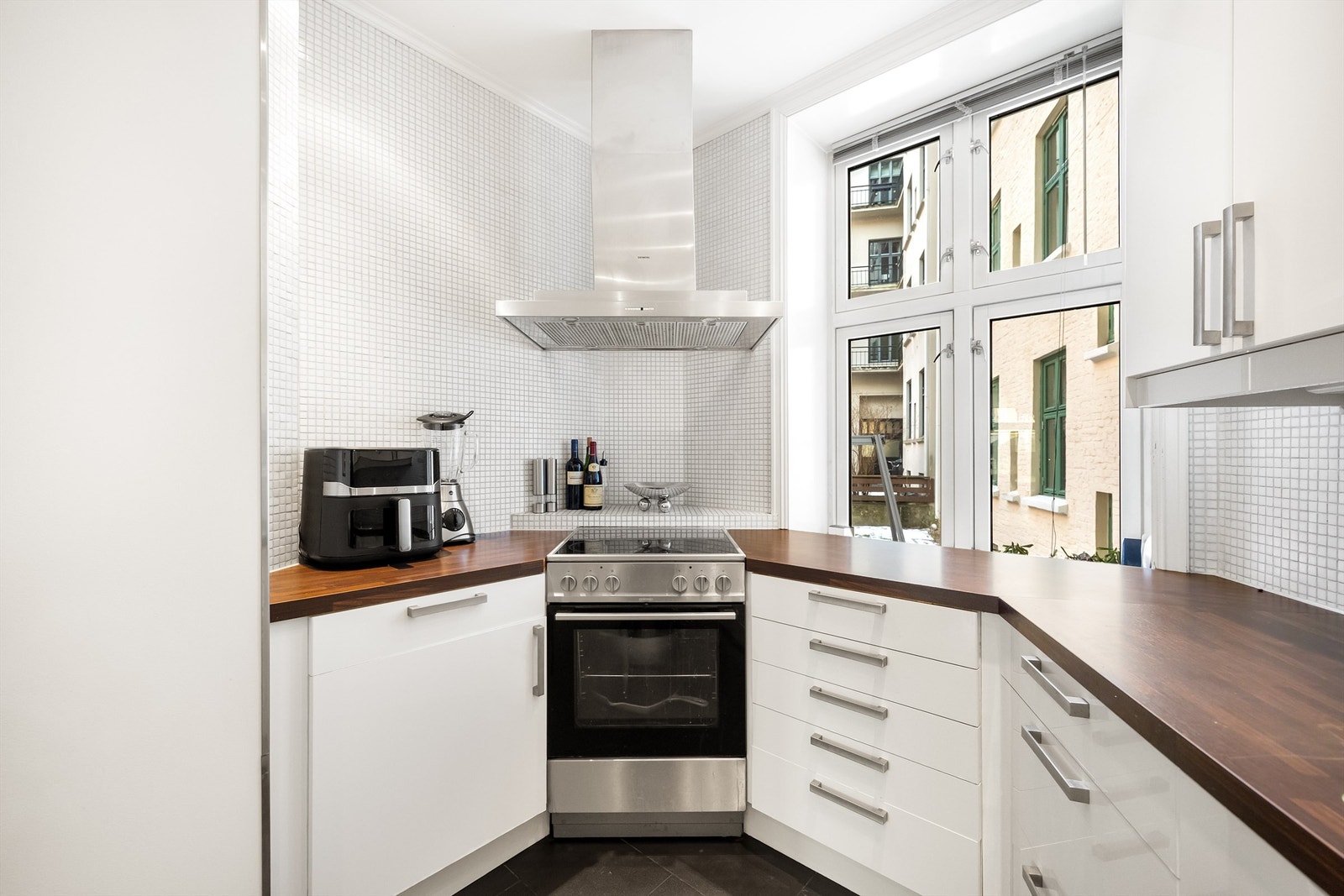 Store vinduer gir rikelig med naturlig lys og skaper en hyggelig atmosfære med utsikt mot bakgård. Galleribilde