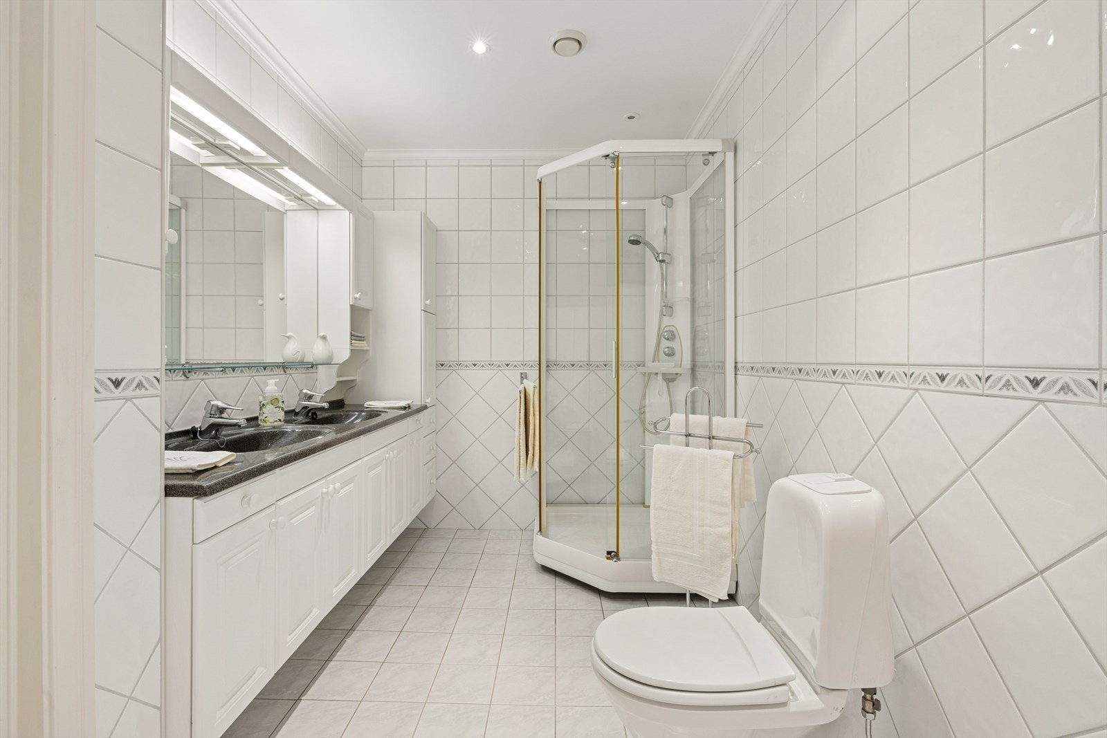 Lyst og velholdt helfliset bad med dobbelservant, varme i gulv, wc og dusjkabinett. Galleribilde