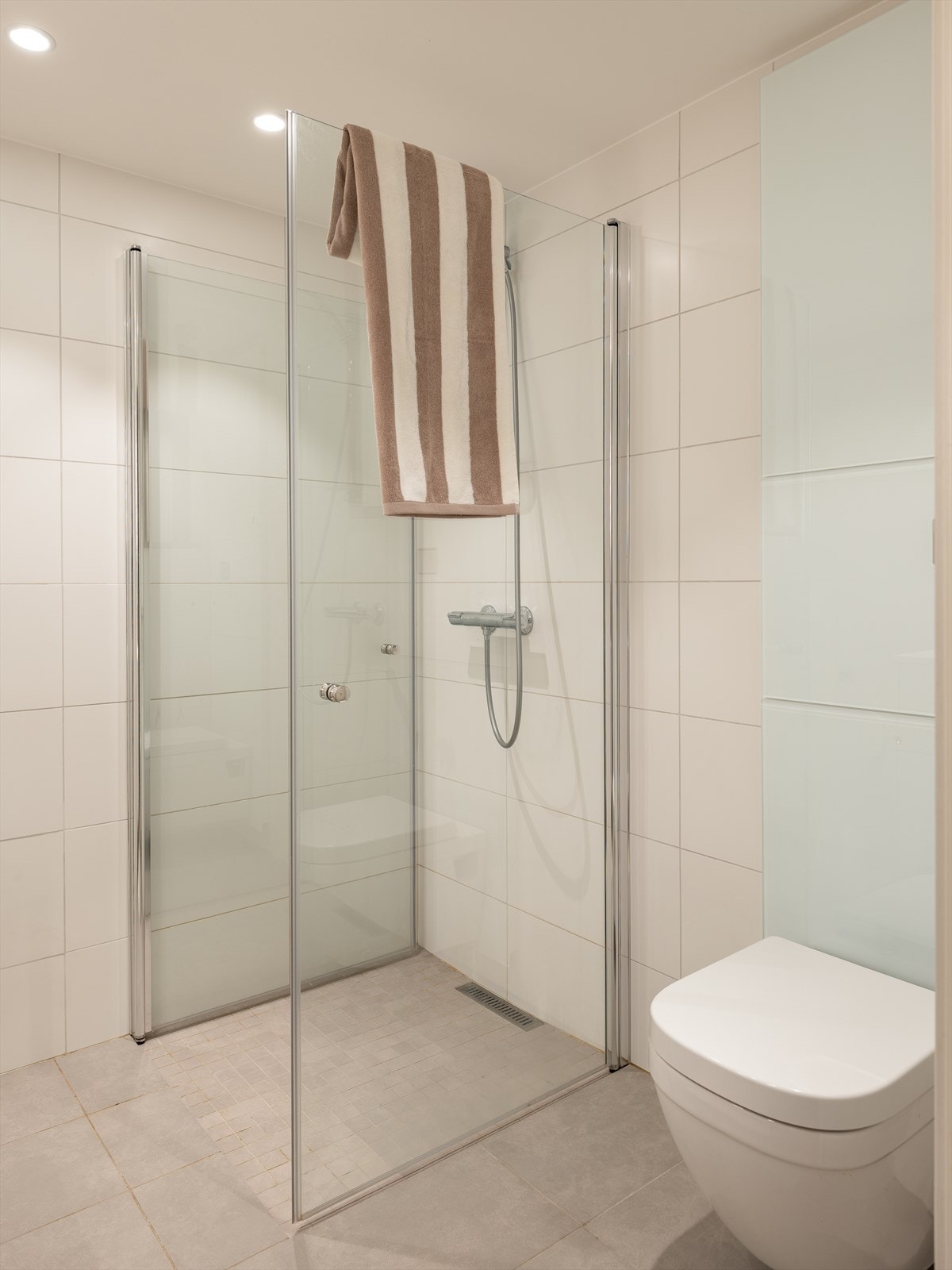 Baderommet er utstyrt med dusjhjørne, mekanisk avtrekk, opplegg for vaskemaskin, servant, servantskap, rørfordelingsskap, veggmontert wc, stoppekran og vannmåler. Galleribilde