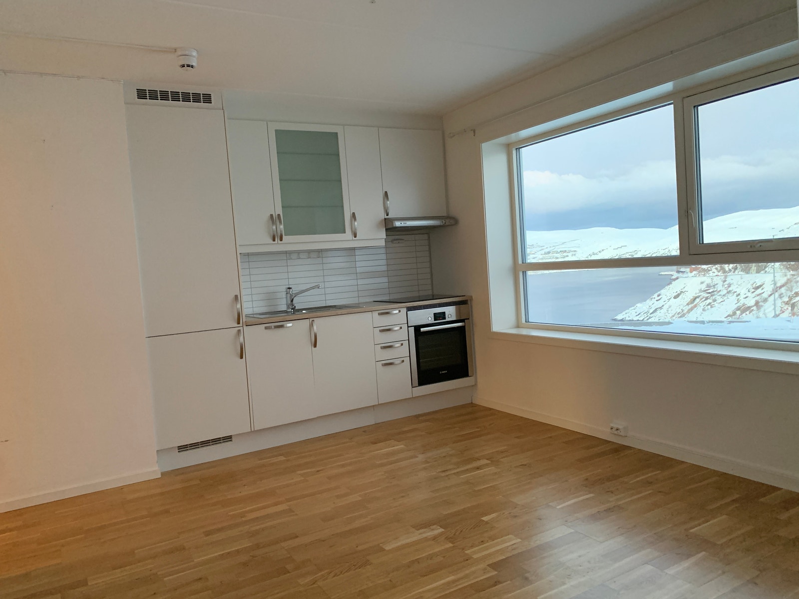 Kompakt stue og kjøkken med store vindusflater. Galleribilde