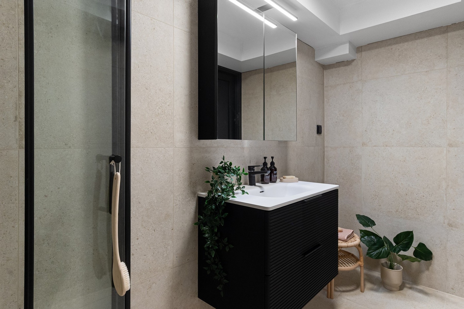 Lekkert helfliset med med 60x60 fliser. Innredet med vegghengt toalett, servant med innredning, speilskap og dusjhjørne med dusjdører i glass som er sammeleggbare. Galleribilde