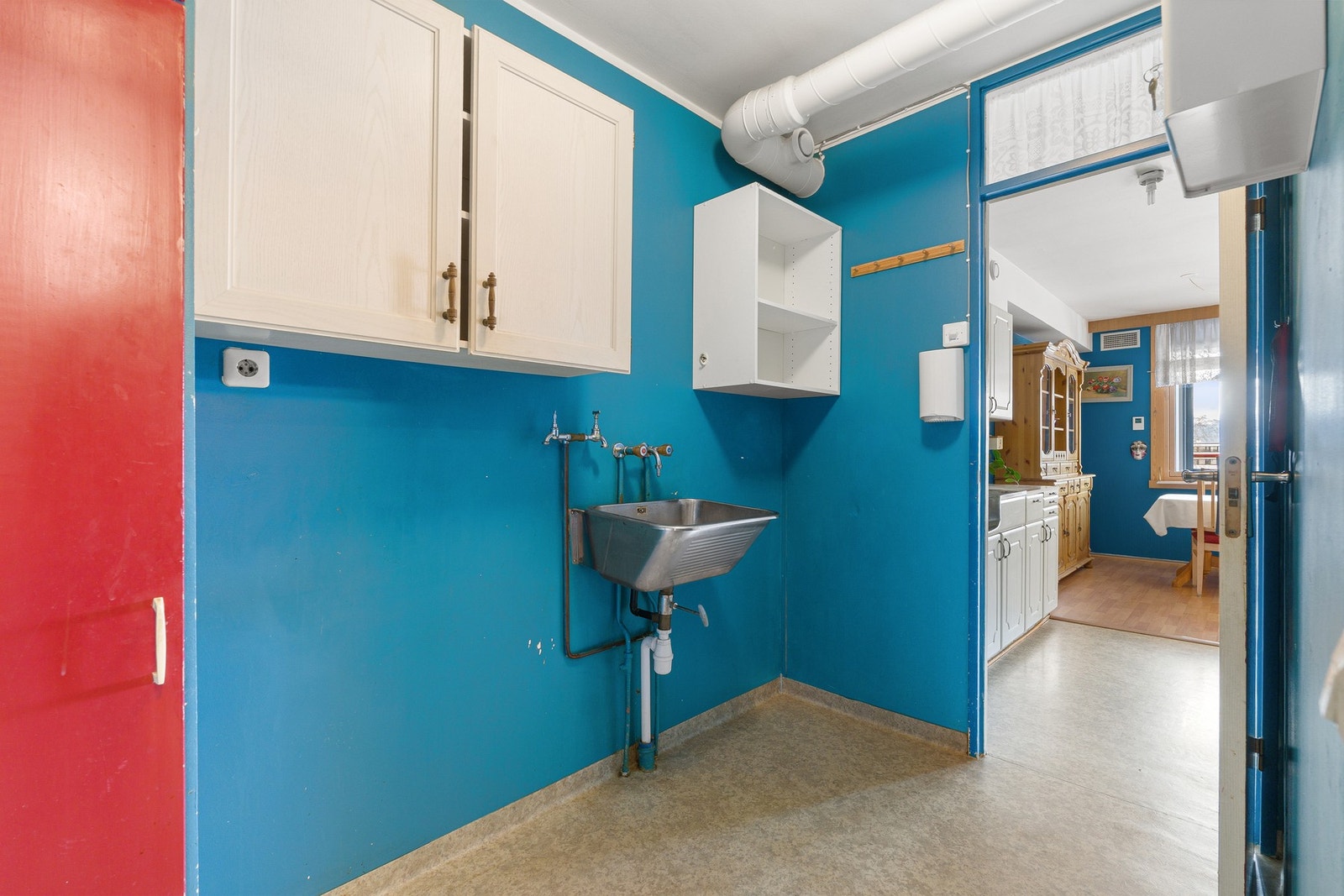 Romslig vaskerom med opplegg for vaskemaskin og utslagsvask. Galleribilde