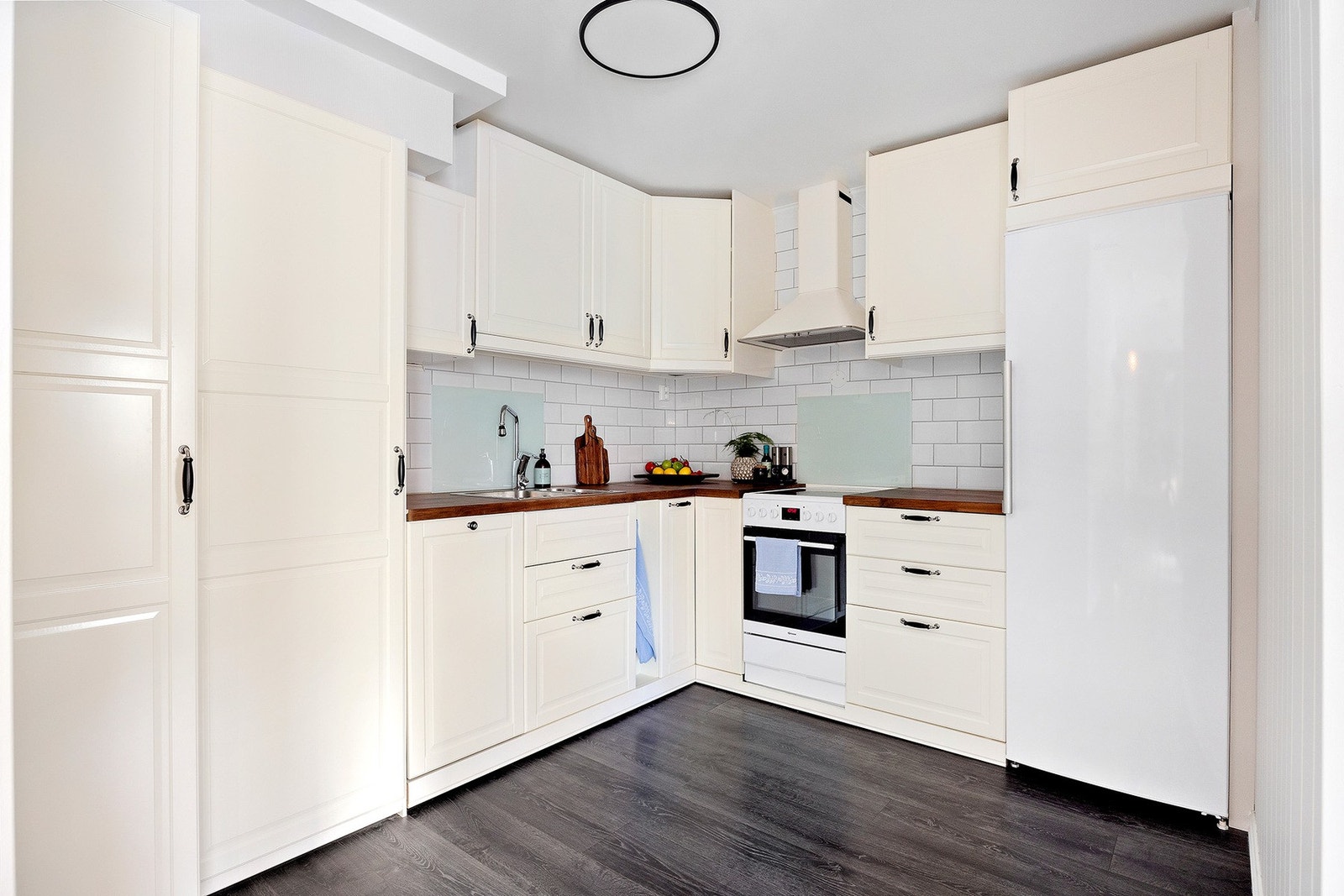 Delvis åpen kjøkkenløsning fra 2019. Det er profilerte fronter med laminat benkeplate. Galleribilde