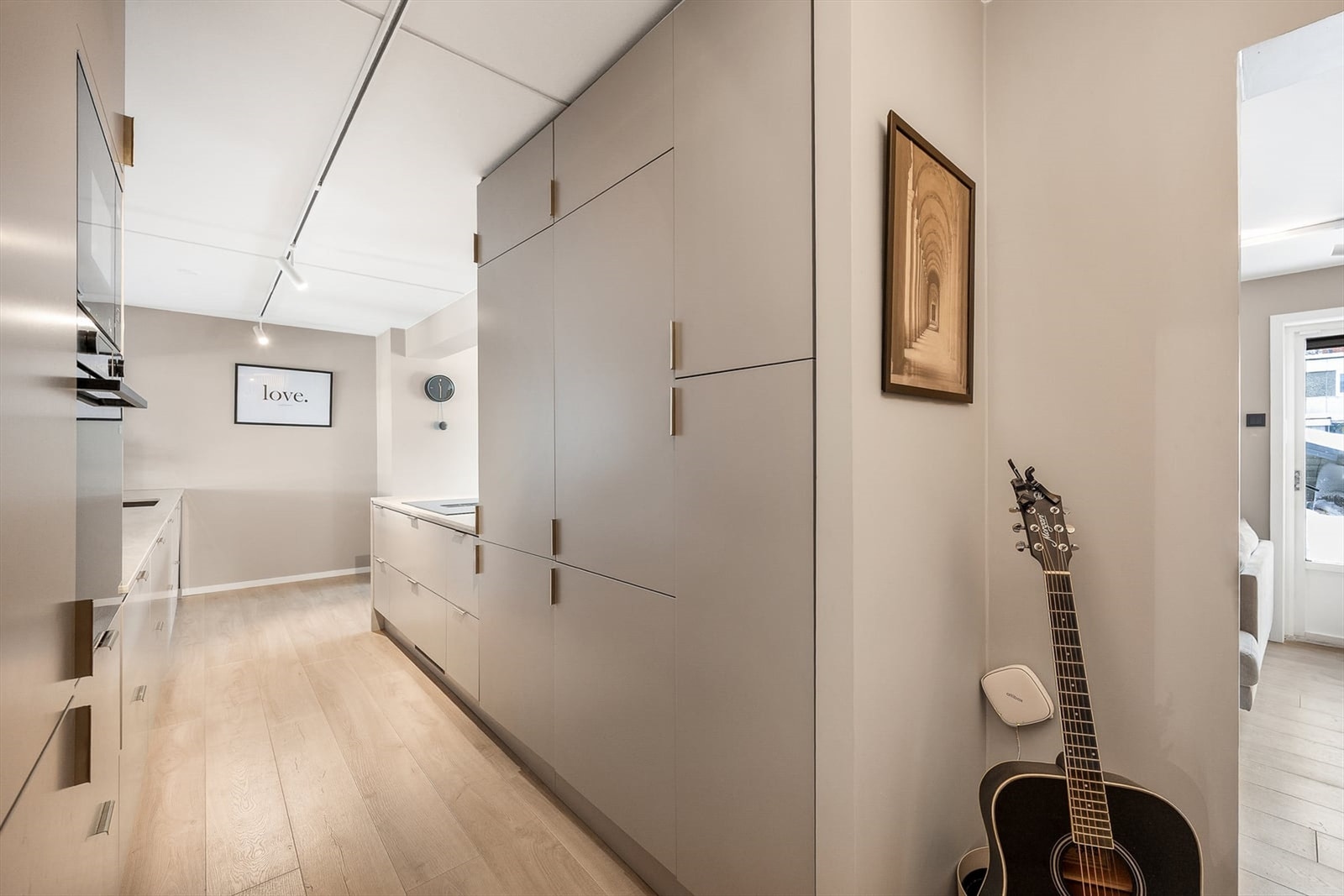 Videre inn i leiligheten kommer man til et stilrent kjøkken med gode løsninger og matrealvalg Galleribilde