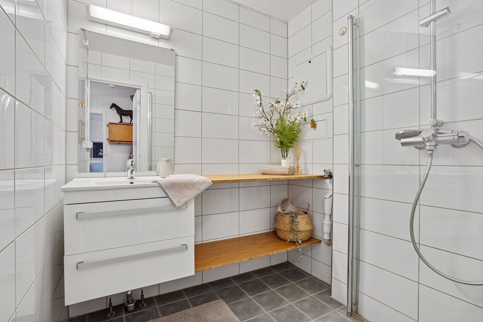 Lyst og fint baderom som ble oppgradert i 2013. Baderommet byr på flislagt gulv med varme, dusjhjørne, opplegg til vaskemaskin og vegghengt servantinnredning. Galleribilde