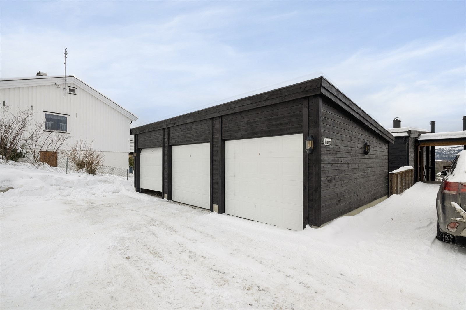 Eiendommen ligger i skrånende terreng hvor det på øvre nivå er grusede parkeringsarealer og felles garasjeanlegg hvor det er mulighet for å kjøpe en garasjeplass om ønskelig. Galleribilde