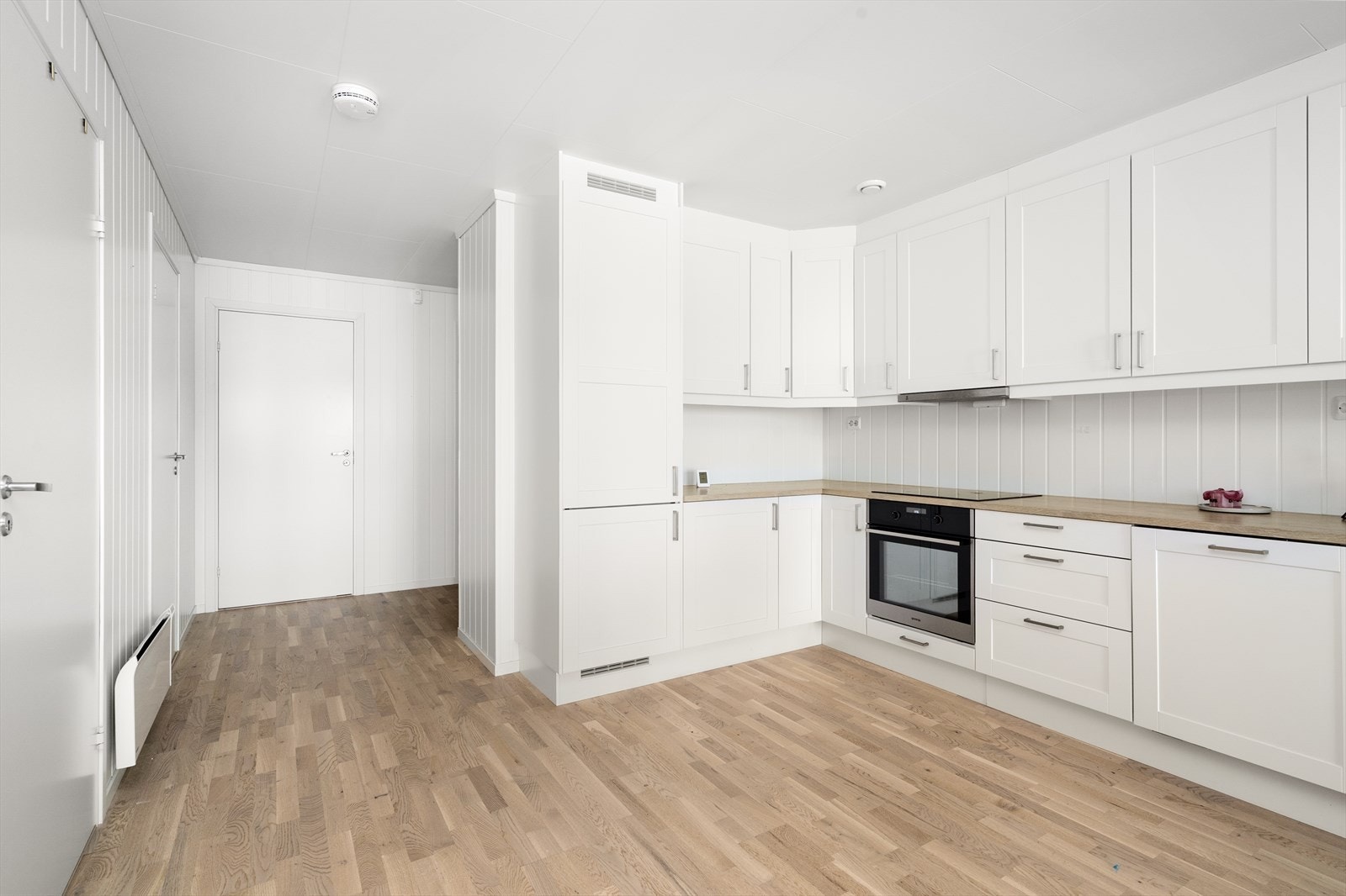 På kjøkkenet er det god oppbevaringsplass i takhøye overskap og i innredningen for øvrig. Gode arbeidsflater på laminert benkeplate, med flere el-stikk over benk. Kjøkkenet har alle hvitevarer integrert. Galleribilde