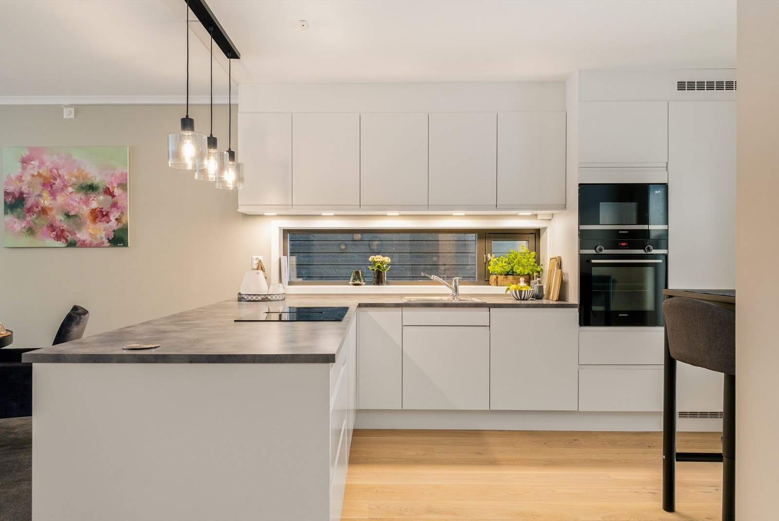 Kjøkkenet er utstyrt med integrerte hvitevarer bestående av kjøl/fryseskap, oppvaskmaskin, induksjonstopp, mikrobølgeovn og stekeovn. Galleribilde