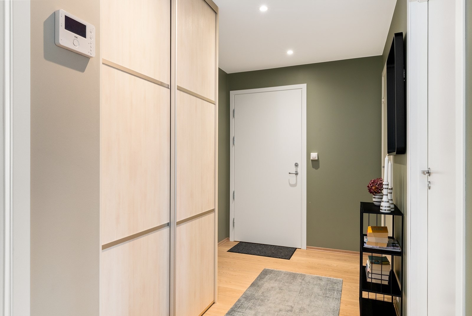 Vel inne ankommer man en innbydende gang hvor det er montert en praktisk skyvedørsgarderobe som sørger for ryddig oppbevaring av yttertøy og sko. Galleribilde