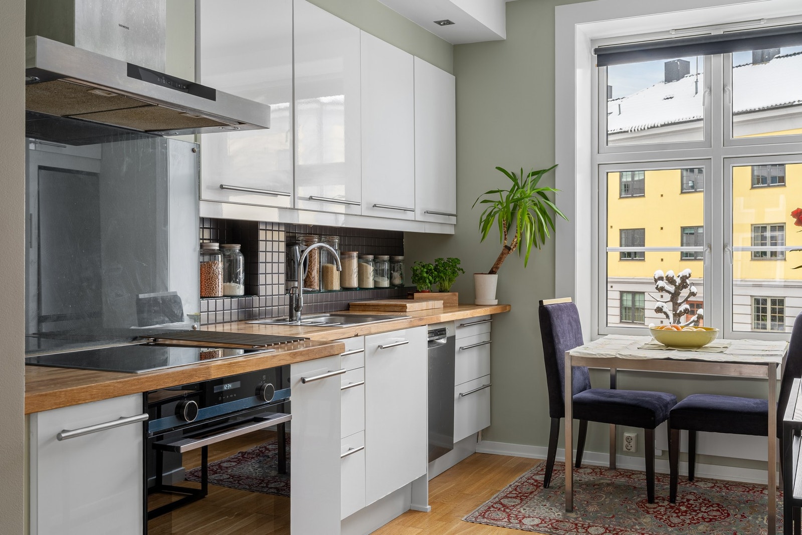 Kjøkkeninnredningen er fra IKEA og byr på eik benkeplater, hetteventilator, glassplate/fliser over benk. Galleribilde