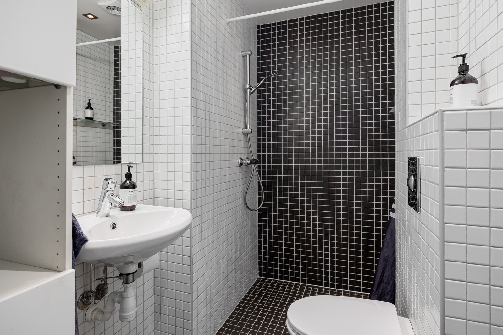 Baderom med flislagte overflater og dusjhjørne. Galleribilde