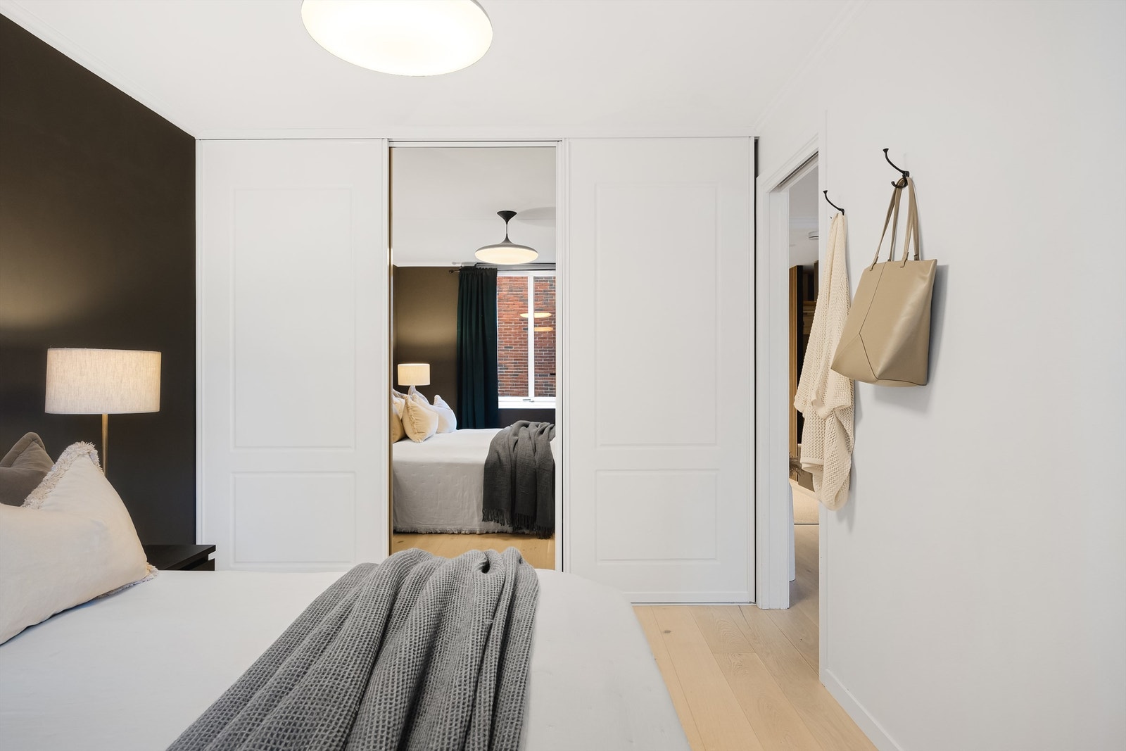 Langs den ene veggen er det vegg-til-vegg skyvedørsgarderobe med speil som gir rikelig med oppbevaringsplass. Galleribilde