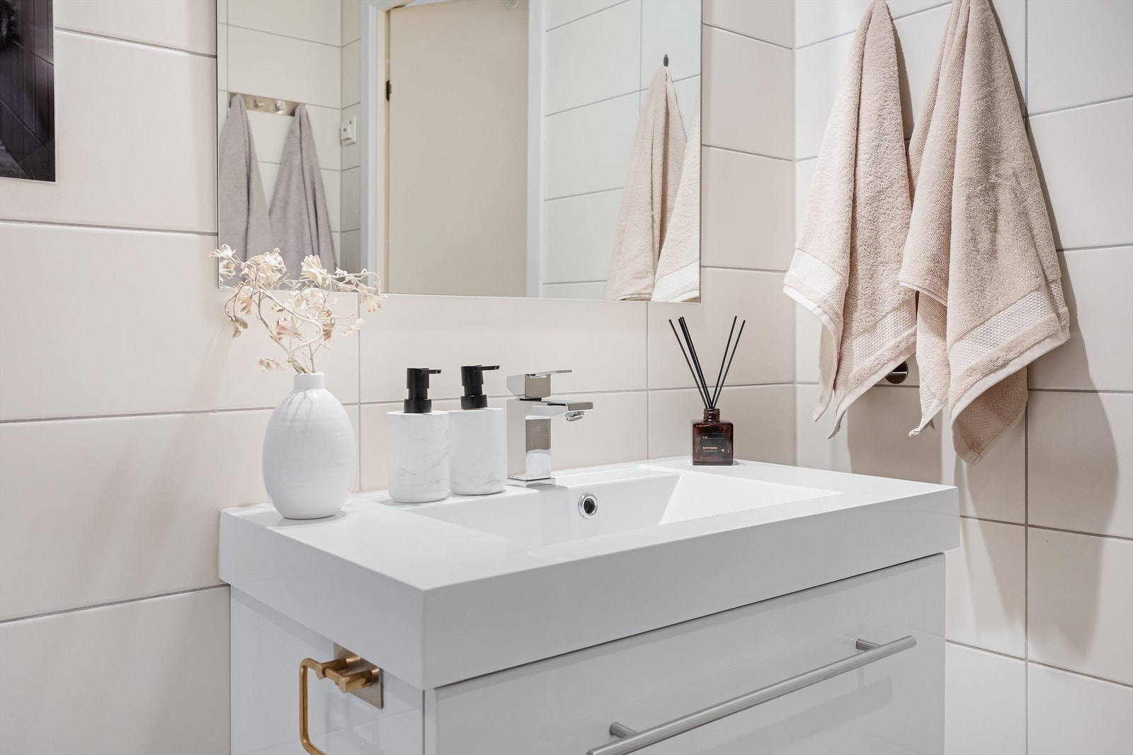 Badet er innredet med servantskap med glatte fronter, komposittservant med ettgreps armatur og vegghengt speil over servant. Galleribilde