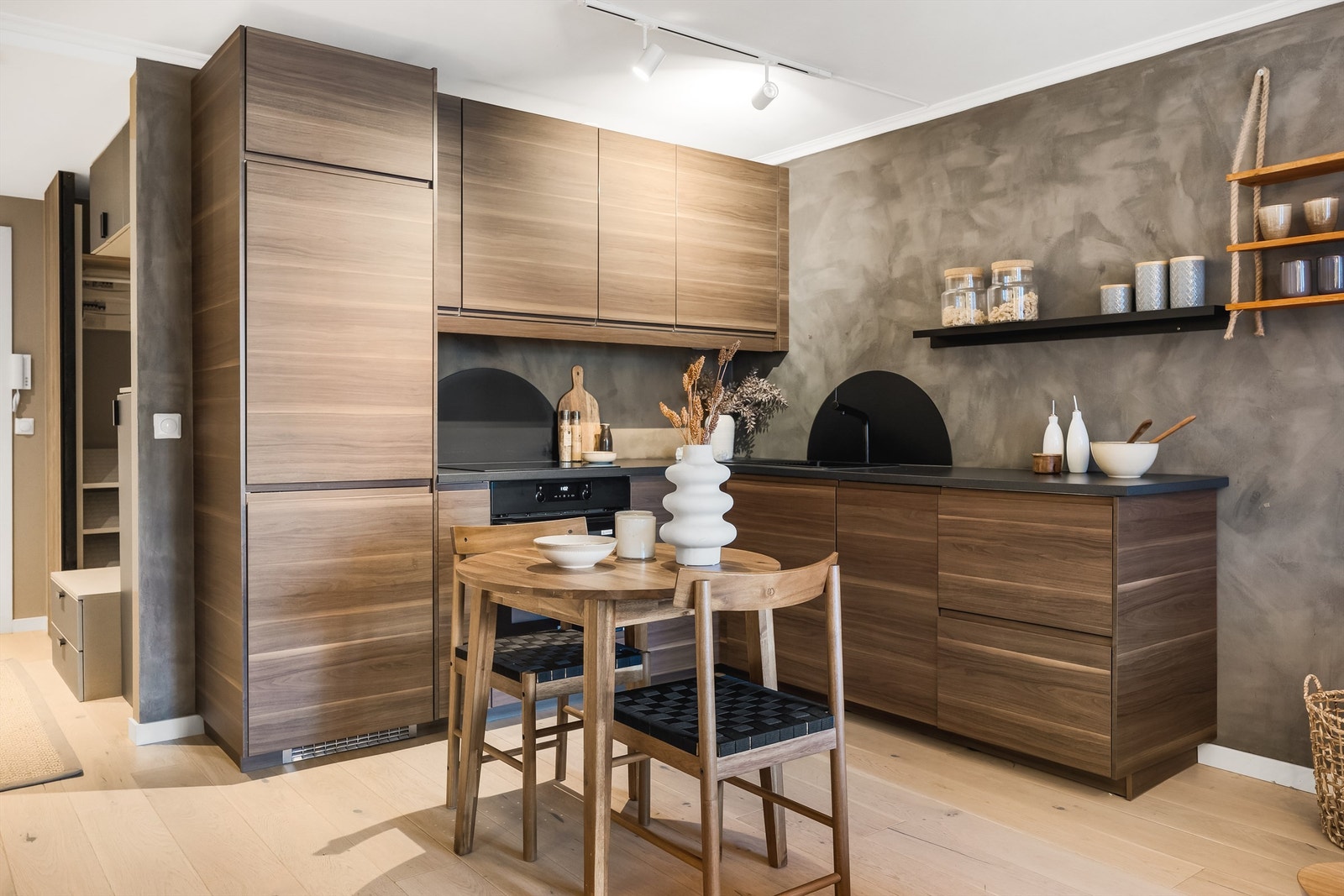 Lekkert IKEA-kjøkken fra 2021 med glatte fronter i hvalnøtt eikemønster og stilrene sorte detaljer. Galleribilde