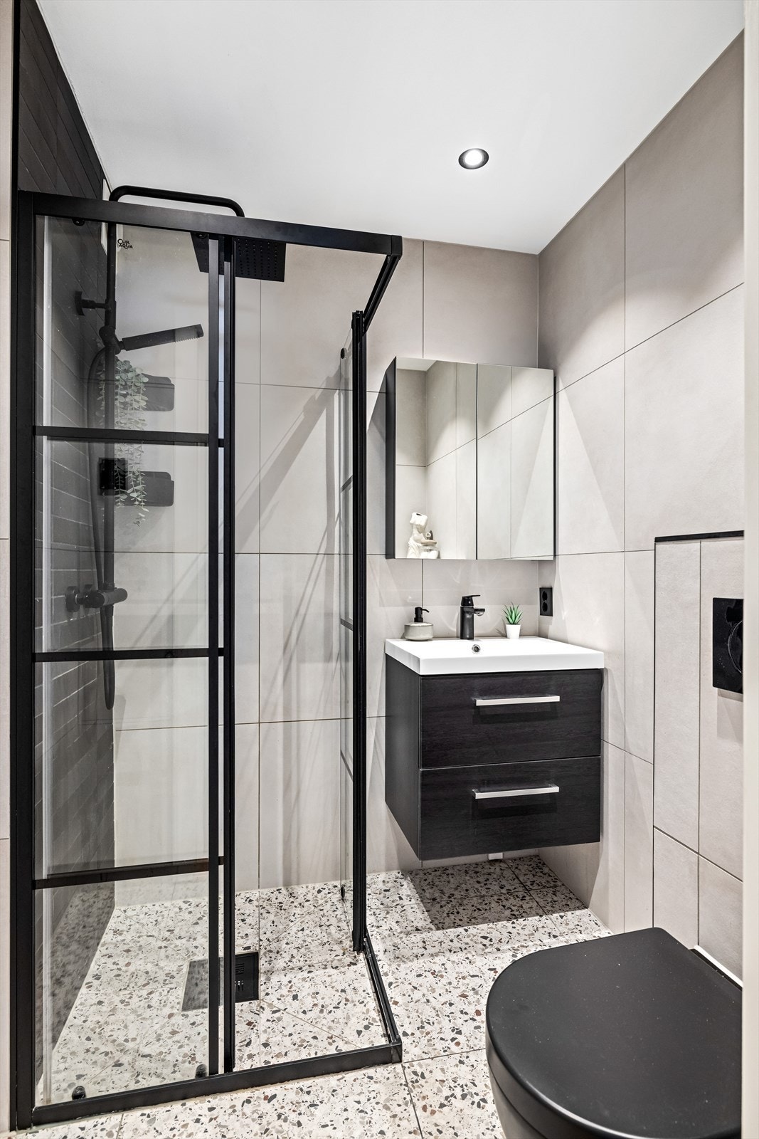 Badet er utstyrt med vegghengt servantskap, speilskap og innebygget sisterne. Galleribilde