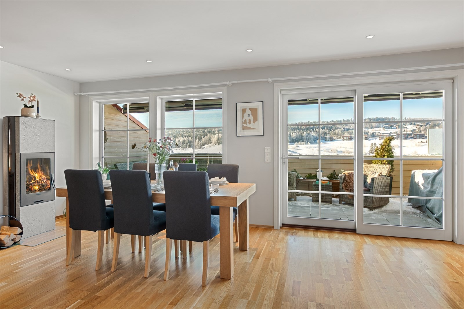 Store vindusflater gir utsyn mot det omkringliggende landskapet fra stuen. Peisovn i stuen bidrar med jevn varme og skaper et behagelig innemiljø. Galleribilde