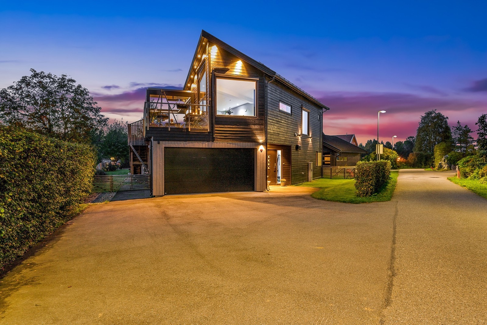 Parkering i integrert garasje med elbillader. Asfaltert gårdsplass. Galleribilde