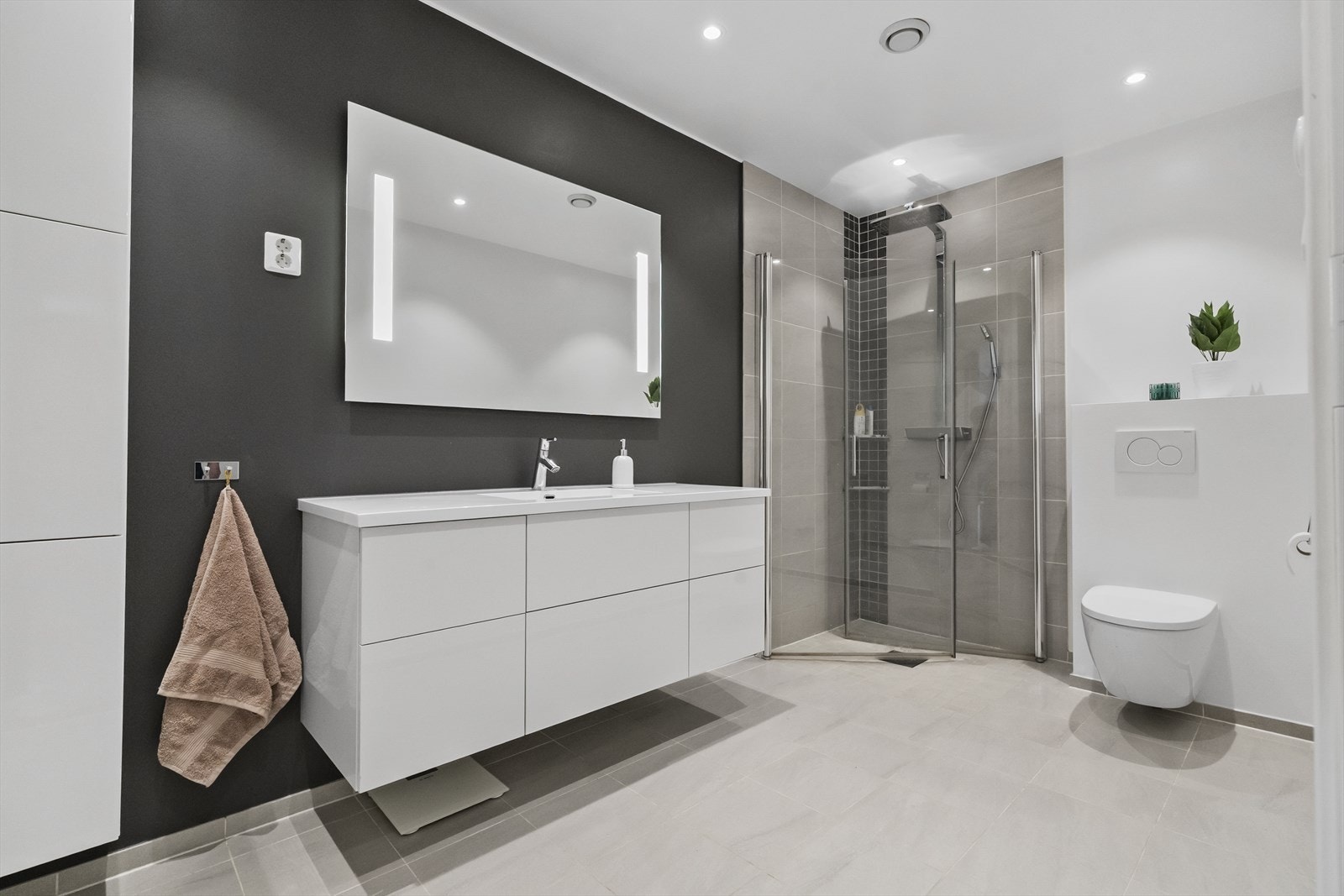 Badet har flislagt golv og flislagt dusjsone. Innhaldsrik baderomsinnreiing med skuffer og sideskåp Galleribilde