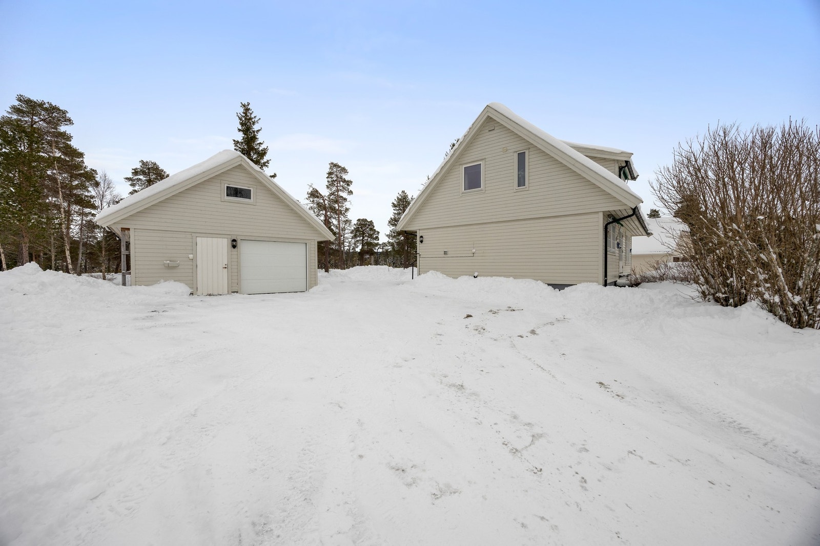 Garasjen står noe utenfor tomtegrensen. Jfr. punkt "tomt" i salgsoppgaven. Galleribilde