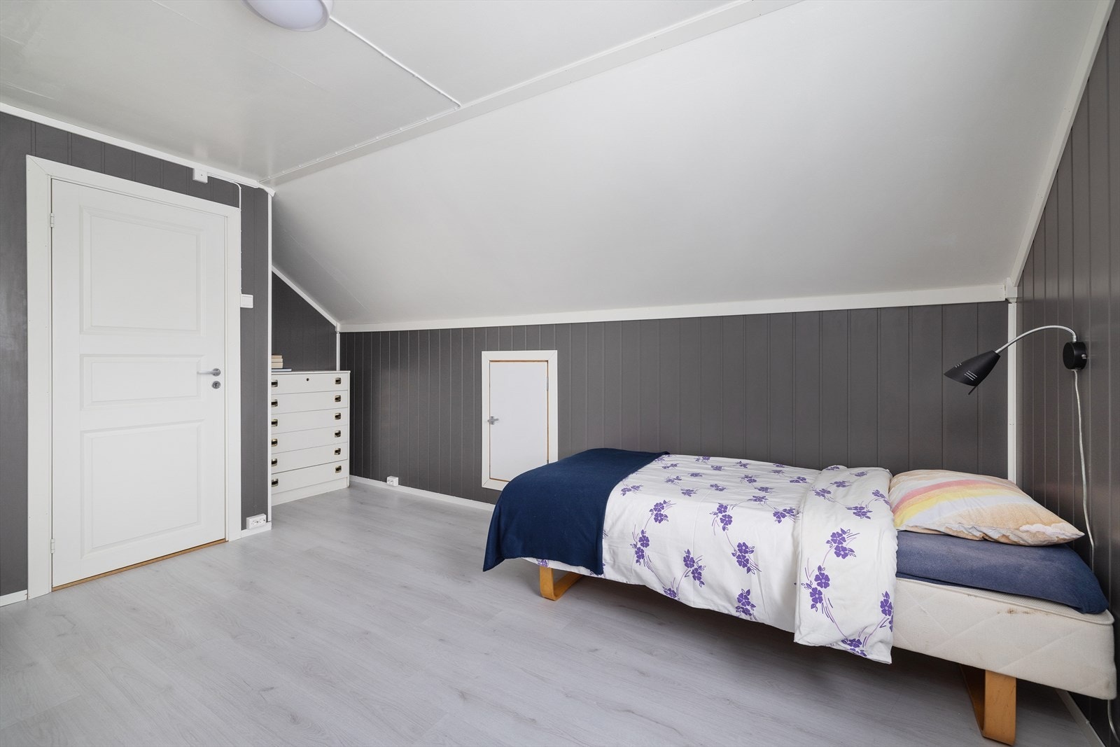 Det ene soverommet på loftet har panelte vegger og laminat på gulvet. Galleribilde