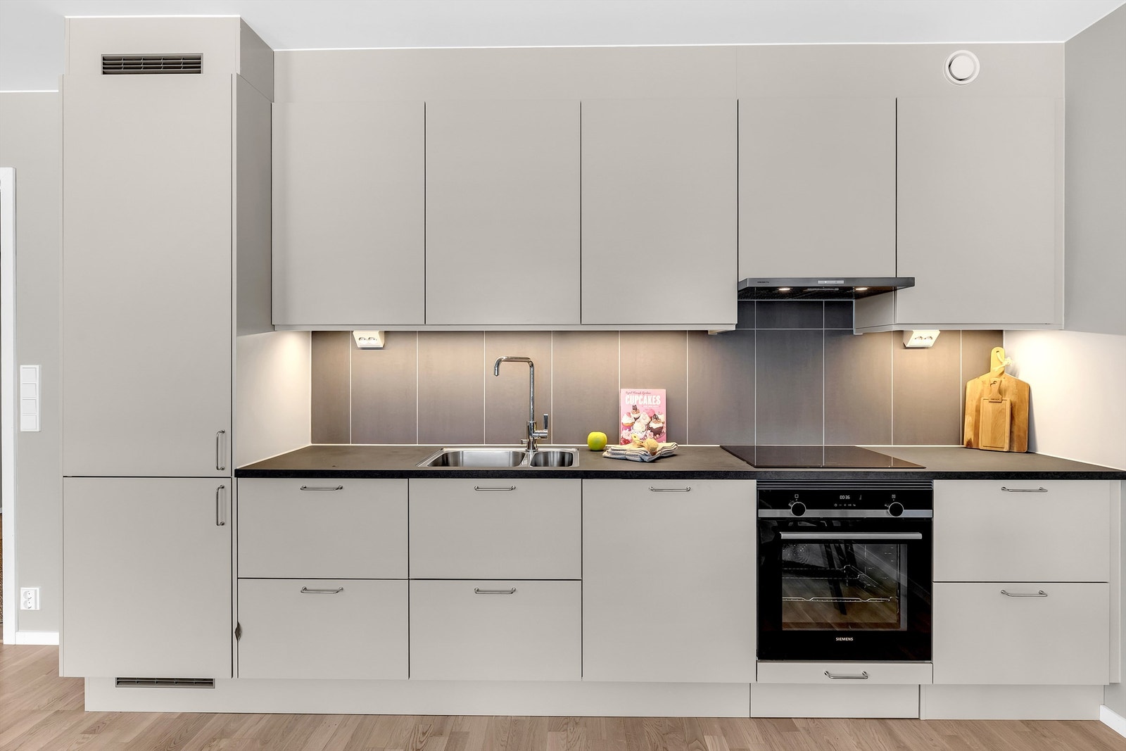 Integrerte hvitevarer som kjøle/fryseskap, oppvaskmaskin, komfyr og induksjonstopp medfølger. Galleribilde