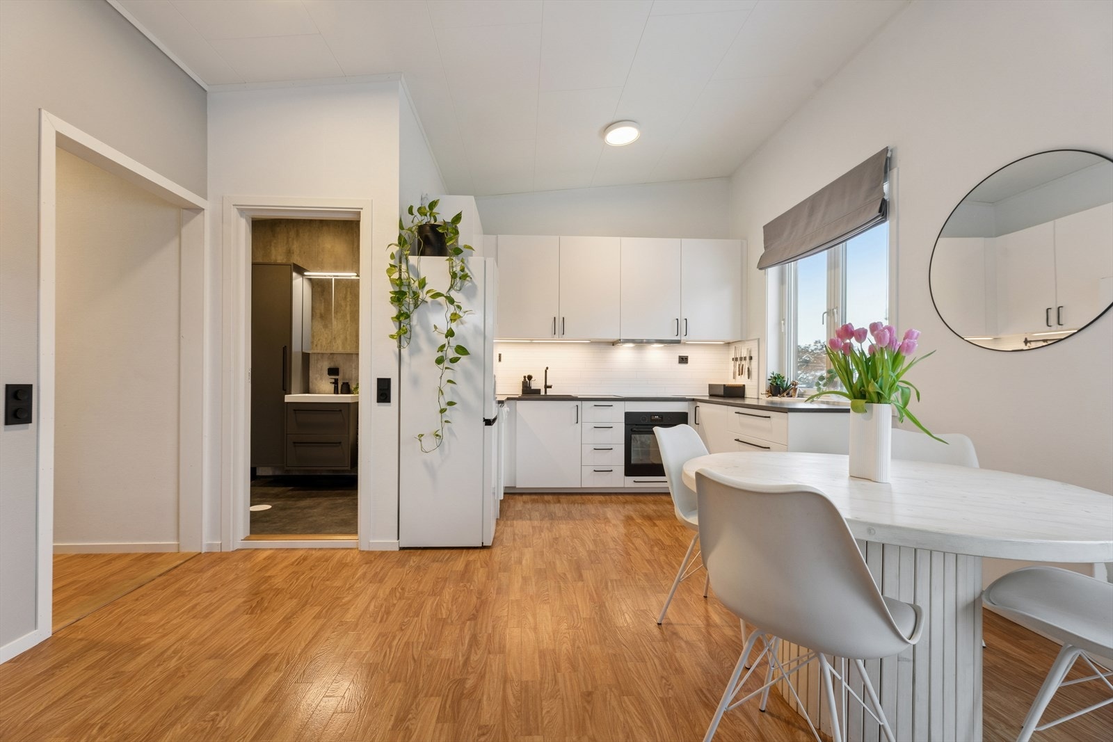 Spisegruppen er smart og innbydende plassert nær kjøkkenet, noe som skaper en praktisk og sosial soneløsning perfekt for både hverdagsmåltider og hyggelige middager. Galleribilde